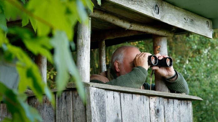 Congress-wants-close-look-at-NCAA-over-athlete-betting-change A man in a hideout looking at something through binoculars