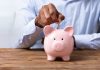 FanDuel and DraftKings pay the price in Illinois in August A person paying a coin into a piggy bank