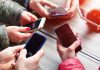 People with their phones being social as PrizePicks debuts a new social feature.
