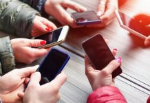 People with their phones being social as PrizePicks debuts a new social feature.