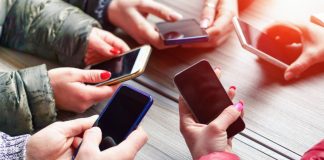 People with their phones being social as PrizePicks debuts a new social feature.