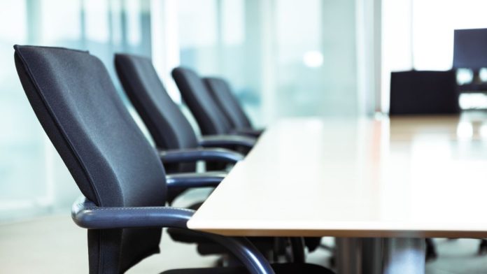 AGA-elects-Delaware-North-CEO-Lou-Jacobs-as-new-chair Chairs around a table in a corporate boardroom