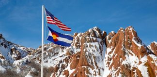 Colorado fines BetMGM $50K for taking $880 in college player props The flags of the U.S. and Colorado flying in front of snowy brown mountains