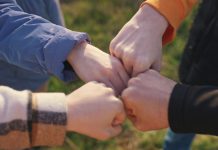 A group of people putting their fists together in unison