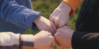 Fanatics joins group of sportsbooks launching prediction markets A group of people putting their fists together in unison