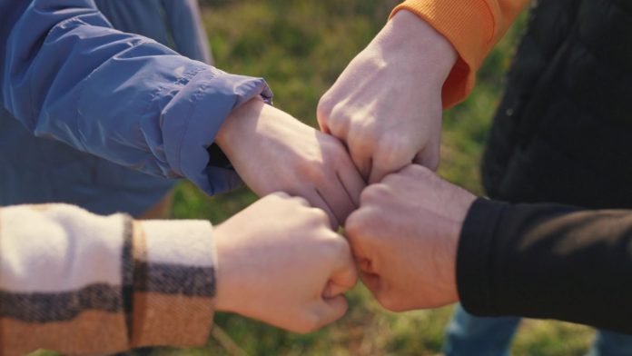 Fanatics-joins-group-of-sportsbooks-entering-prediction-market-sector A group of people putting their fists together in unison