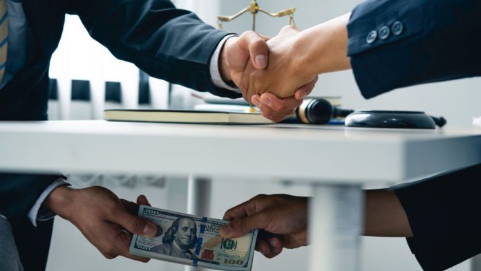 Florida-Bribes-Measure-Sports-Betting Men shake hands as Florida lawmakers consider a measure that criminalizes sports bribes.