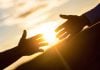 Two people's arms reaching out to each other for help