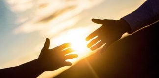 Genius Sports suggests prediction markets may need its help Two people's arms reaching out to each other for help