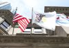 The flags of the USA, the state of Illinois and the city of Chicago flying from a building