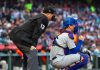 An MLB umpire and a catcher wait for a pitcher to pitch
