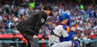 An MLB umpire and a catcher wait for a pitcher to pitch