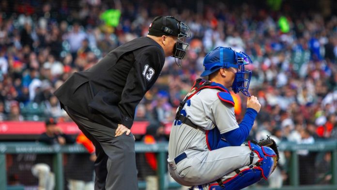 An MLB umpire and a catcher wait for a pitcher to pitch