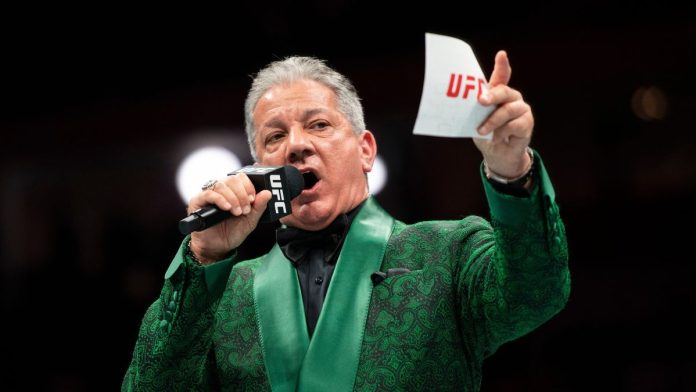 A UFC announcer holding a UFC-branded microphone and card before a fight