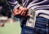 PrizePicks unveils new early exit payout feature A person putting U.S. banknotes in his back pocket