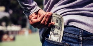 PrizePicks unveils new early exit payout feature A person putting U.S. banknotes in his back pocket