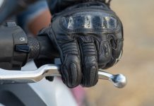 A person riding a motorbike pressing the brake lever