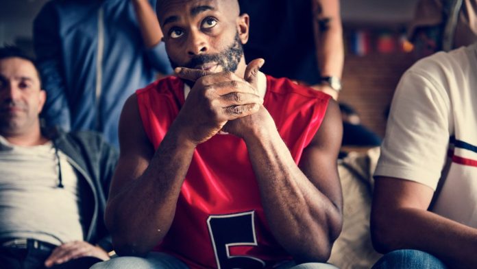 YouGov-survey-finds-Americans-losing-trust-in-sporting-integrity Basketball fans looking skeptical while watching a game