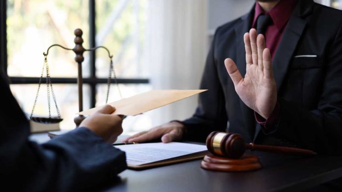 Hand rejecting envelope in judicial setting
