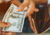 DraftKings MLB market error leads to nearly $3 million in customer payouts Person taking money out their wallet as DraftKings is required to handle payouts.