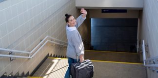 Fanatics no longer an American Gaming Association member A woman waving goodbye over her shoulder as she heads to catch a subway train with a suitcase