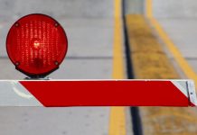 A barrier keeping people out of a certain area, with a red warning light