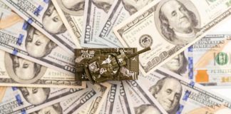 Toy tank sitting on a pile of hundred dollar bills