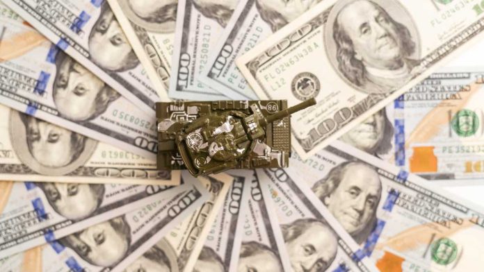 Toy tank sitting on a pile of hundred dollar bills