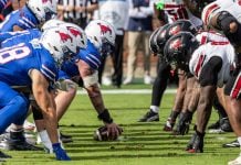 SMU Mustangs and Louisville Cardinals players face off during a NCAA football game