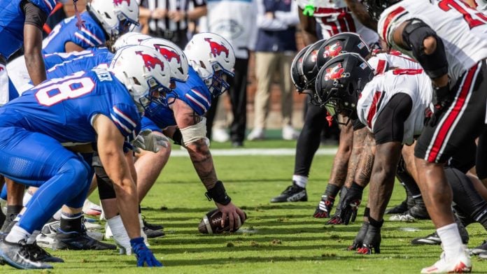 SMU Mustangs and Louisville Cardinals players face off during a NCAA football game