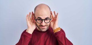 Man holding hands to both ears to indicate listening