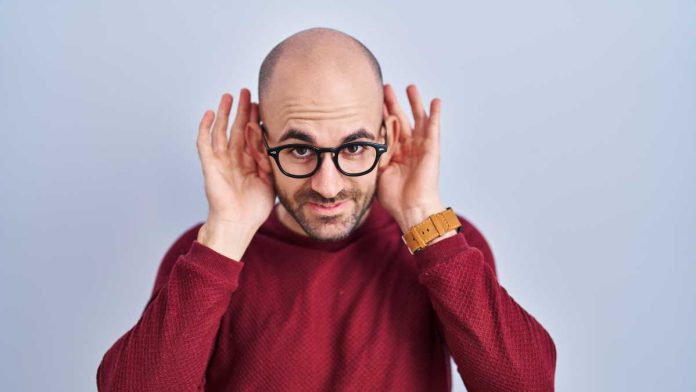 NJ-in-game-prop-ban-hearing Man holding hands to both ears to indicate listening