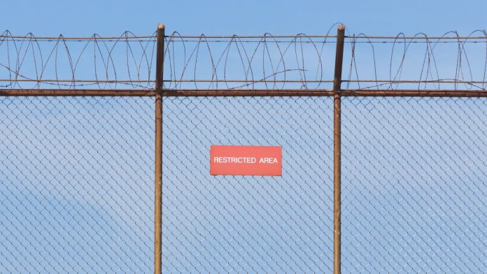 Nevada-regulators-want-Wayne-Nix-blacklisted A barbed wire fence with a restricted sign on it