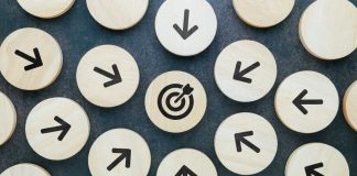 Wooden blocks with arrows pointing towards wooden block with target