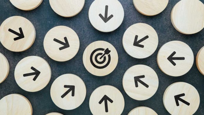 Wooden blocks with arrows pointing towards wooden block with target