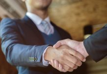 PrizePicks continues to build policy team with Zabriskie hiring A man shaking hands as PrizePicks hires a new member to its policy team.