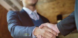 A man shaking hands as PrizePicks hires a new member to its policy team.