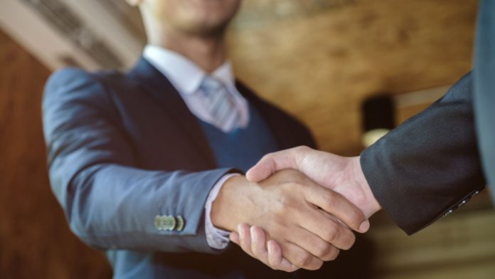A man shaking hands as PrizePicks hires a new member to its policy team.