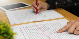 Hands with red pen editing document