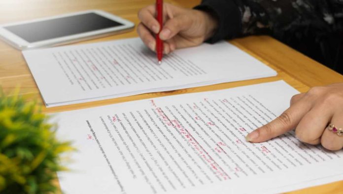 US-Sportsbooks-Revise-Betting-Catalogs Hands with red pen editing document
