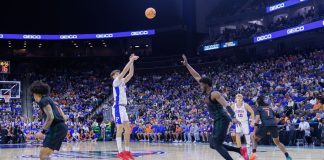 A player shoots over a guard during an NCAA college basketball game