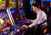 A man playing a slot machine in a casino