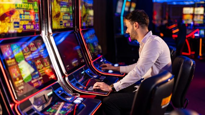 A man playing a slot machine in a casino