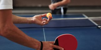 A person preparing to serve in a table tennis game