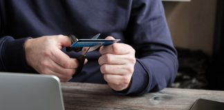 Virginia may consider banning credit cards for sports betting A person sat by a laptop cutting up a credit card