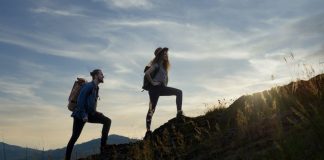 West Virginia sports betting, iGaming tax hikes on table for 2026 Two hikers silhouetted by the sun while walking up a mountain