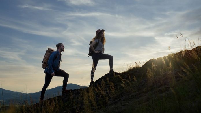 West-Virginia-Delegate-Proposes-Pair-of-Gambling-Tax-Hikes Two hikers silhouetted by the sun while walking up a mountain