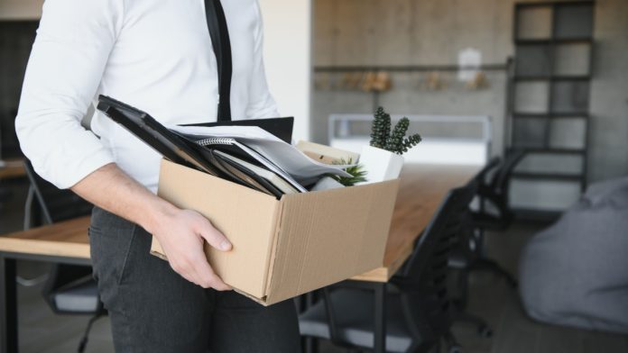 DraftKings-Job-Cuts-Reorganization A person packing up their office as DraftKings is set to undergo a series of layoffs.