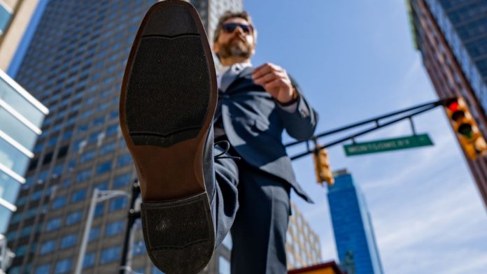 View from underneath of a businessman taking a stride forward