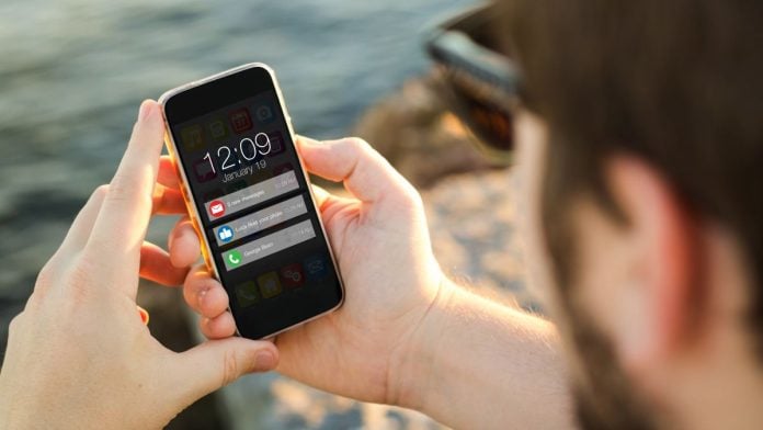 A person looking at his phone screen as it displays several new notifications